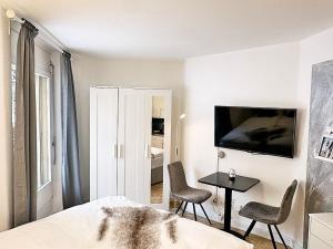 um quarto com uma cama, uma mesa e cadeiras em Im Zentrum, 2 Personen mit Garage (Pool) - CB102 em St. Moritz