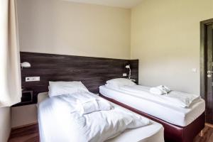 2 Betten in einem Hotelzimmer mit weißer Bettwäsche in der Unterkunft Boutique Hotel Anna by EJ Hotels in Holt