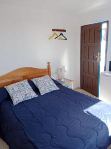 een bed met een blauw dekbed in een slaapkamer bij Casa Rural Merche in Chío