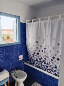 a bathroom with a shower curtain and a toilet at Casa Rural Merche in Chío