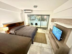 a bedroom with a bed and a flat screen tv at Apartamento en Recoleta in Buenos Aires