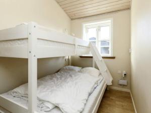 ein weißes Etagenbett in einem Zimmer mit Fenster in der Unterkunft Holiday home Nysted IX in Nysted