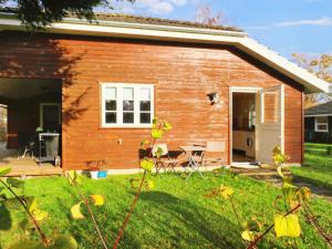 ein kleines Backsteinhaus mit einer Terrasse und einem Hof in der Unterkunft Holiday home Nysted IX in Nysted