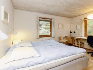 1 dormitorio con 1 cama blanca grande y escritorio en Holiday home Gedser XXXV, en Gedser