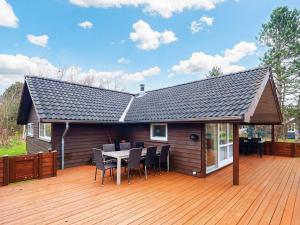 ロービュにある8 person holiday home in Rødby-By Traumのデッキにテーブルと椅子が備わる家