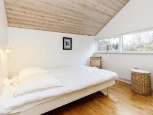 um quarto com uma cama branca num quarto com uma janela em Holiday Home Klintevej II em Rødby