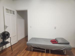 a bed in a room with a white wall at Casa Ipê Baobá in Sao Paulo