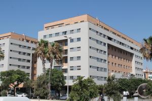 un edificio bianco con palme di fronte di Paseo Maritimo a Málaga