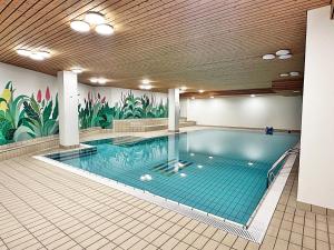 a large swimming pool in a building with a mural at Im Zentrum, 2 Personen mit Garage (Pool) - CB102 in St. Moritz