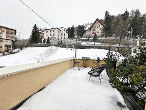 a snow covered roof with two chairs and a table at Im Zentrum, 2 Personen mit Garage (Pool) - CB102 in St. Moritz