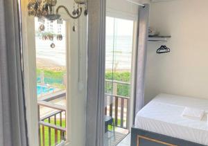 a bedroom with a view of the ocean from a balcony at Pousada São Miguel Beach Beira Mar in Penha