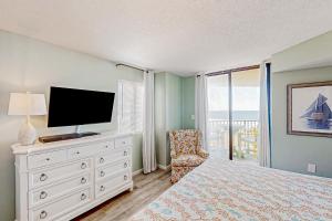 um quarto com uma cama, uma televisão e uma cadeira em The Summit 2-A em Myrtle Beach