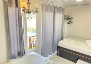 a bathroom with a bath tub next to a window at Pousada São Miguel Beach Beira Mar in Penha