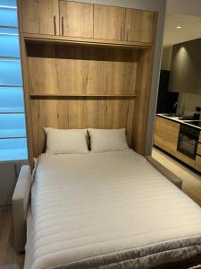 a bedroom with a large bed with a wooden headboard at BW Lux Apartments in Sajmište