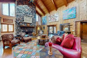 a living room with a red leather couch and a stone wall at Sawtooth Serenity in Hailey
