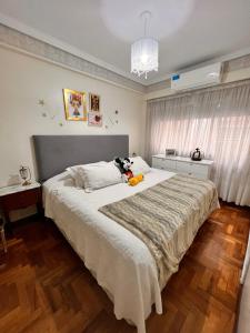 a bedroom with a large bed with two stuffed animals on it at Apartamento Belgrano in Buenos Aires
