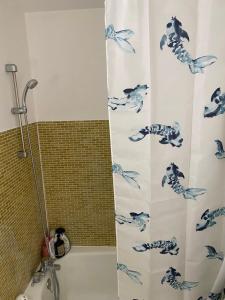 cortina de ducha con pescado azul en el baño en Room close to Arena La Défense paris en Nanterre