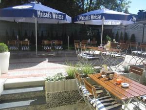 an outdoor patio with tables and chairs and umbrellas at Hotel 9-enhof in Wuppertal