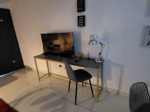 a desk with a lamp and a chair in a room at Apartamento #6 cómodo, Tranquilo, Elegante cerca de la estación del metro de la cincuentenario in Panama City