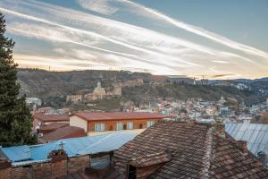 a view of a city with buildings and a mountain at Sunny Hotel Tbilisi in Tbilisi City