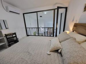 a bedroom with a large bed with a large window at Apartamento #6 cómodo, Tranquilo, Elegante cerca de la estación del metro de la cincuentenario in Panama City