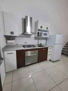 a kitchen with a stove and a refrigerator at Loft Centrico Tranquilo Elegante APART #6 in Panama City