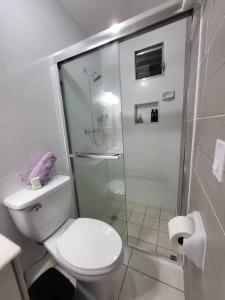 a white bathroom with a toilet and a shower at Loft Centrico Tranquilo Elegante APART #6 in Panama City