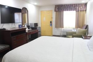 ein Hotelzimmer mit einem Bett und einem Schreibtisch und einem Schlafzimmer in der Unterkunft Rodeway Inn Tucumcari in Tucumcari