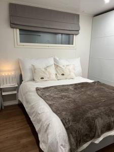 een slaapkamer met een groot bed met witte lakens en kussens bij Arctic Circle Guesthouse in Rovaniemi