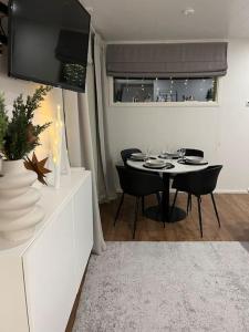 ein Esszimmer mit einem Tisch, Stühlen und einem TV in der Unterkunft Arctic Circle Guesthouse in Rovaniemi