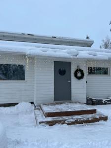 uma casa com uma porta coberta de neve em Arctic Circle Guesthouse em Rovaniemi