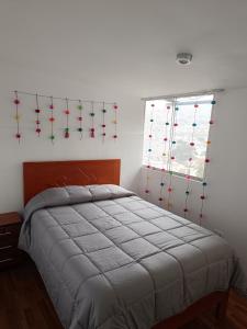 a bedroom with a bed with red and green arrows on the wall at Apartamento Mirador San Blas in Cusco