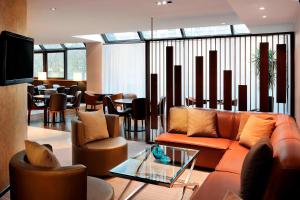 パリにあるパリ マリオット リブ ゴーシュ ホテル ＆ カンファレンスセンターのリビングルーム(ソファ、椅子、テーブル付)