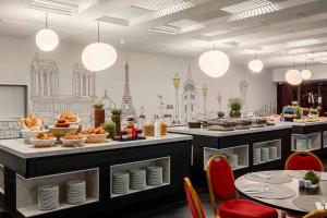 a restaurant with a buffet with tables and chairs at Paris Marriott Rive Gauche Hotel & Conference Center in Paris
