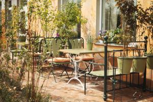 una mesa y sillas en un jardín con plantas en Noclegi Moya Ameryka w Dolinie Baryczy, en Milicz