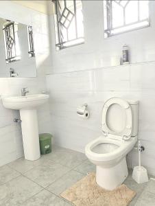 een witte badkamer met een toilet en een wastafel bij 3 BDR Luxurious Villa in Milimani Kisumu in Kisumu