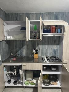 a kitchen with white cabinets and a counter top at Tropicoco Pool House Steps From The Beach in Puerto Nuevo