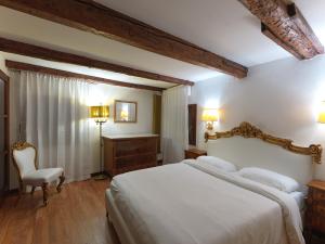 a bedroom with a large white bed and a chair at LaLux Venezia in Venice