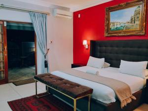 a bedroom with a large bed with a red wall at Red Apple Guest House in Pretoria