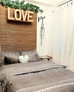 a bedroom with a love sign above a bed at Dolores Residences Sean's Flat in General Santos