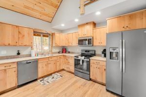 una cucina con armadietti in legno ed elettrodomestici in acciaio inossidabile di Experience Montana Cabins - Big Sky Cabin #1 a Bigfork