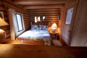 um quarto com uma cama num chalé de madeira em Experience Montana Cabins - Wildflower #3 em Bigfork