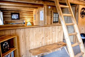 a wooden cabin with a wooden ladder in it at Experience Montana Cabins - Cowboy #5 in Bigfork