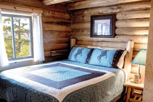 1 dormitorio con 1 cama en una cabaña de madera en Experience Montana Cabins - Cowboy #5, en Bigfork
