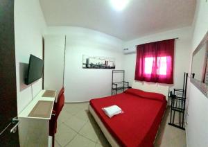 a small bedroom with a red bed and a desk at Catania Home Cibali in Catania
