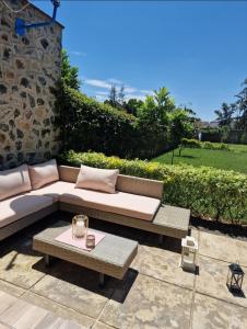 eine Terrasse mit einem Sofa und einem Tisch in der Unterkunft 3 BDR Luxurious Villa in Milimani Kisumu in Kisumu