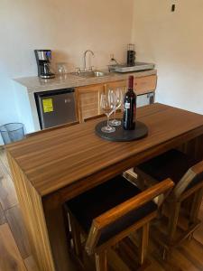 a kitchen with a wooden counter with two glasses of wine at Cabaña Beto’s in Mazamitla