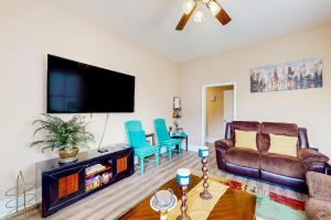 a living room with a couch and a flat screen tv at Betty's Beach House in Galveston