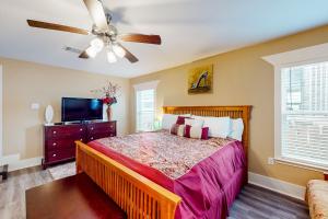 a bedroom with a bed and a ceiling fan at Betty's Beach House in Galveston