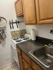 a kitchen with a stove and a sink at Park Ave Apartments Midtown Next to Times Square in New York
